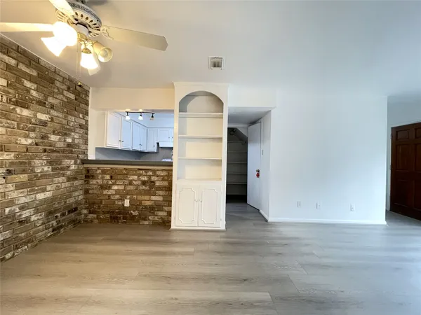 a view of a livingroom with wooden floor and a ceiling fan