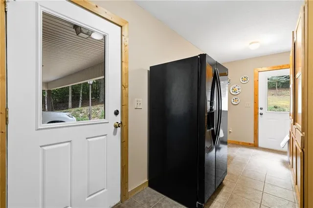 a view of hallway with cabinets and refrigerator
