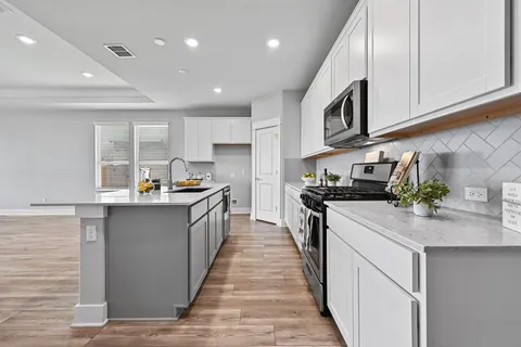 a kitchen with stainless steel appliances granite countertop a sink and dishwasher a stove top oven with wooden floor
