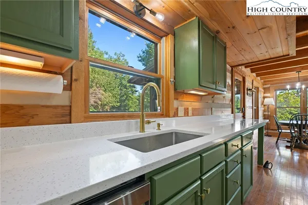 a kitchen with granite countertop a sink a stove and wooden cabinets