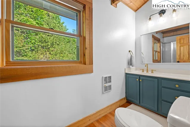 a bed sitting in a spacious bedroom next to a window