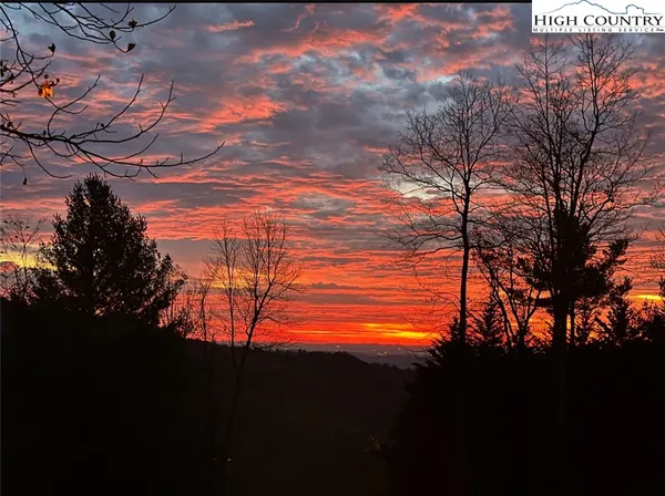 a view of wooden house with a small yard and wooden fence