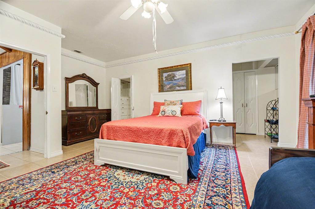 14140 Hillcrest Road Dallas, TX 75254 - Photo 11 of 29 a bedroom with a bed and a lamp on dresser