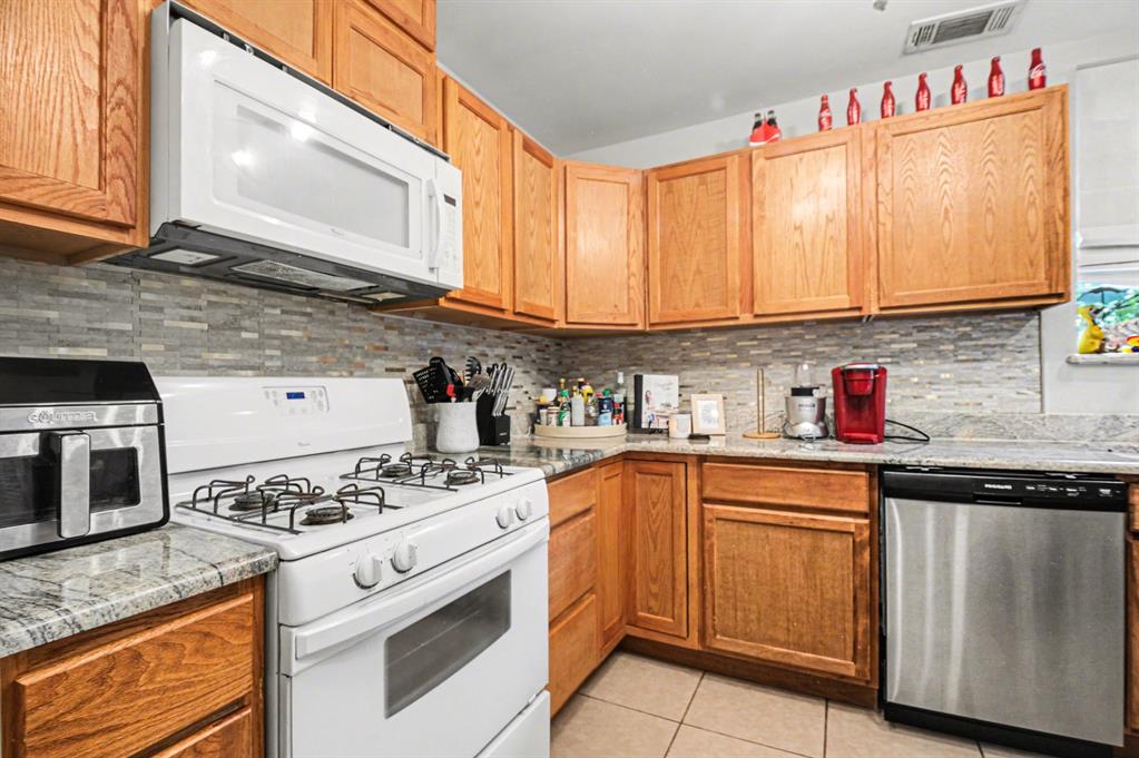 14140 Hillcrest Road Dallas, TX 75254 - Photo 22 of 29 a kitchen with stainless steel appliances granite countertop a stove sink and cabinets
