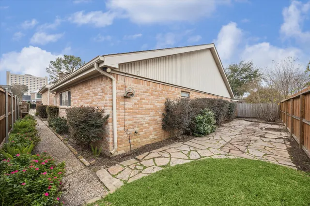a view of house with potted plants and a large window