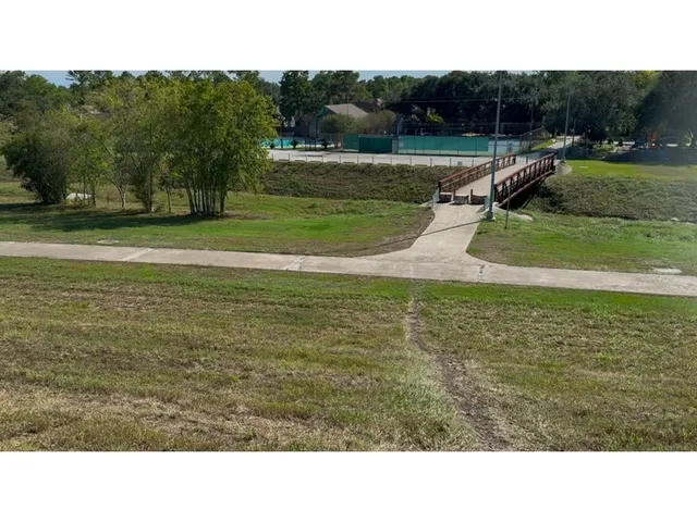 a view of a tennis ground with large trees