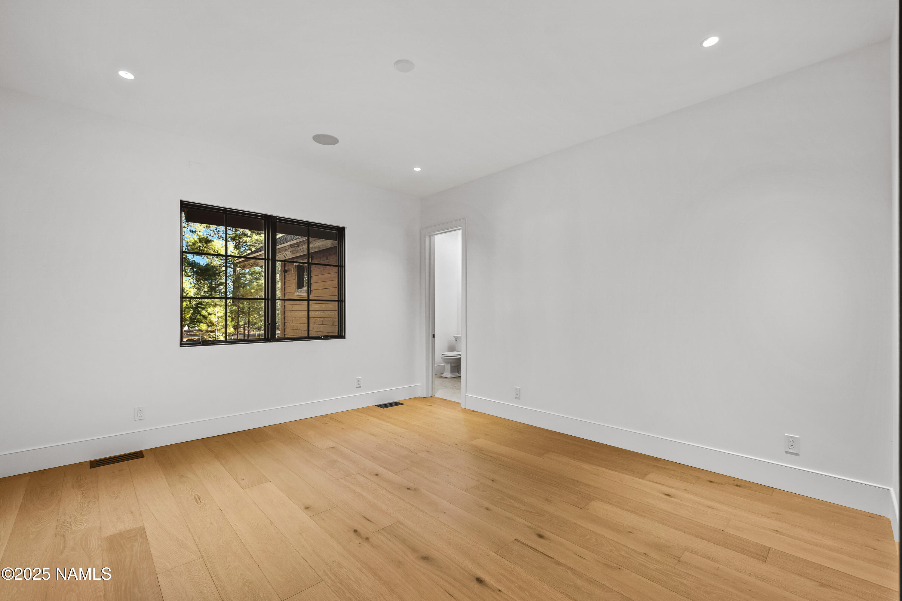 2732 Lindberg Flagstaff, AZ 86005 - Photo 29 of 56 a view of an empty room with wooden floor and a window