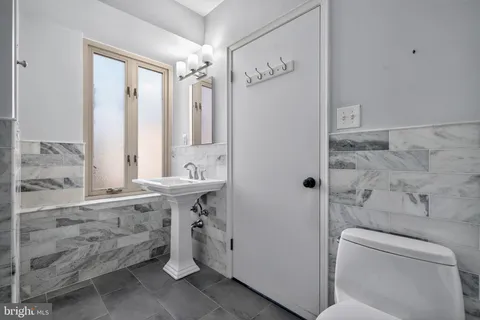 a bathroom with a granite countertop shower a toilet and a shower