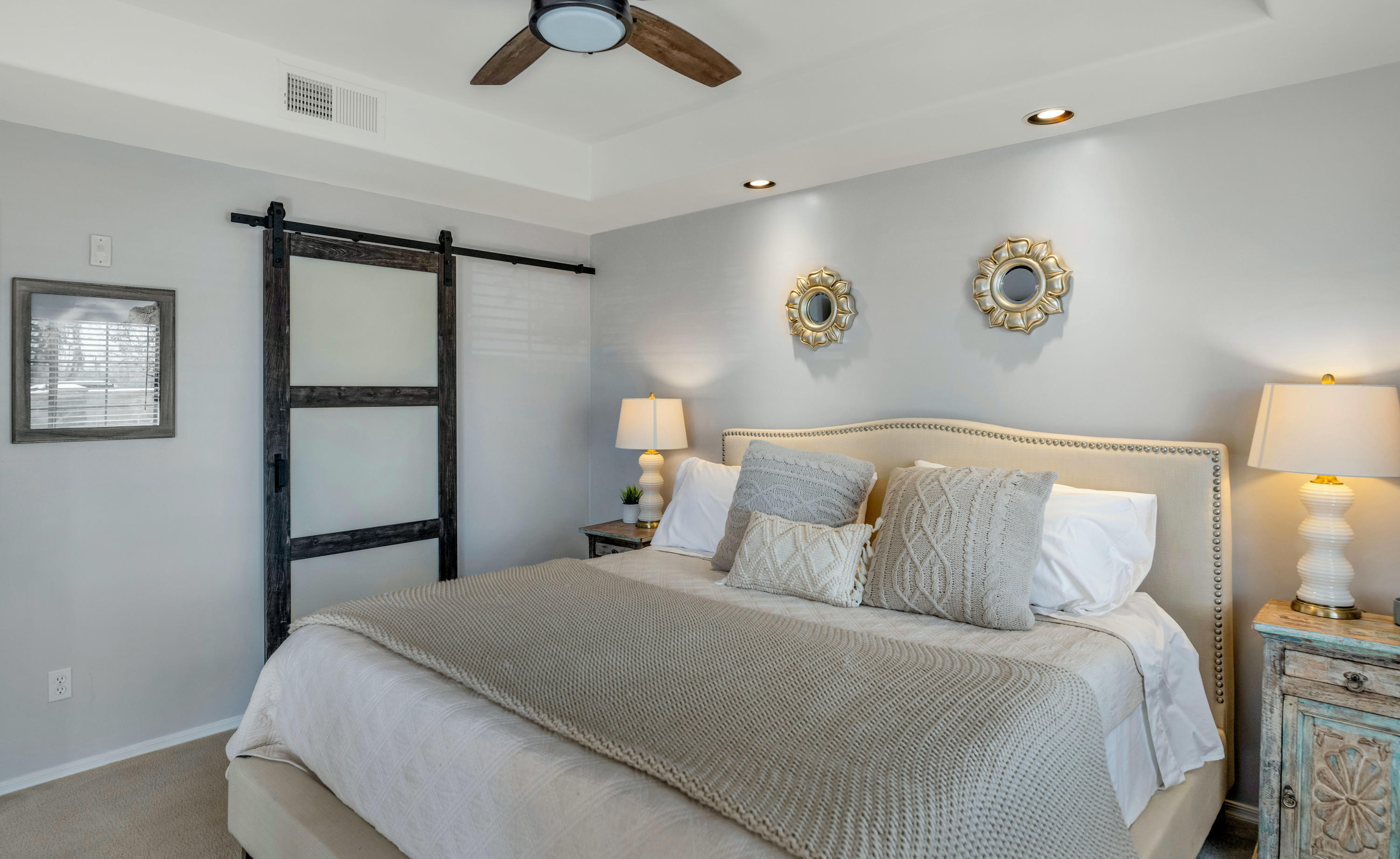 7609 East Indian Bend Road, Unit 1015 Scottsdale, AZ 85250 - Photo 13 of 30 a bedroom with a large bed and a chandelier