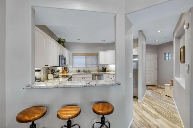 a kitchen with stainless steel appliances granite countertop a refrigerator and a sink