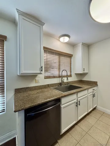 a kitchen with granite countertop a sink and cabinets