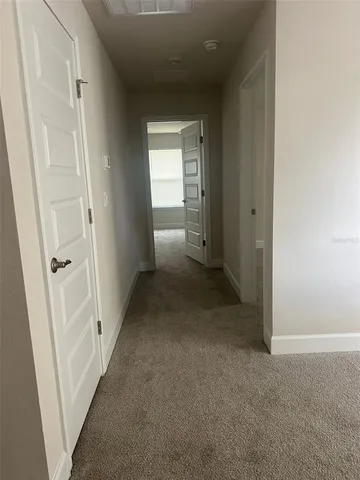a view of a hallway with wooden shelves