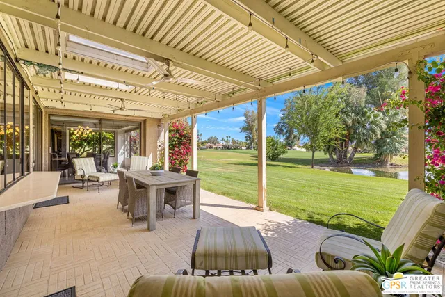 a view of a patio with couches table and chairs and potted plants