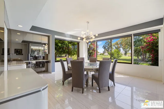 a dining room with wooden floor glass table and chairs