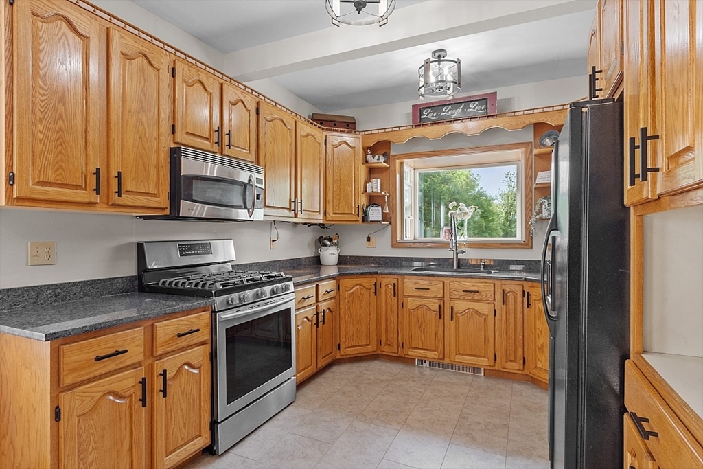 304 Patriots Road Templeton, MA 01468 - Photo 17 of 39 a kitchen with stainless steel appliances granite countertop a stove a sink and a microwave
