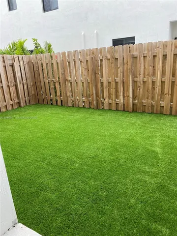 a view of a backyard with wooden fence