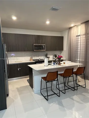 a kitchen with stainless steel appliances kitchen island granite countertop a sink and cabinets