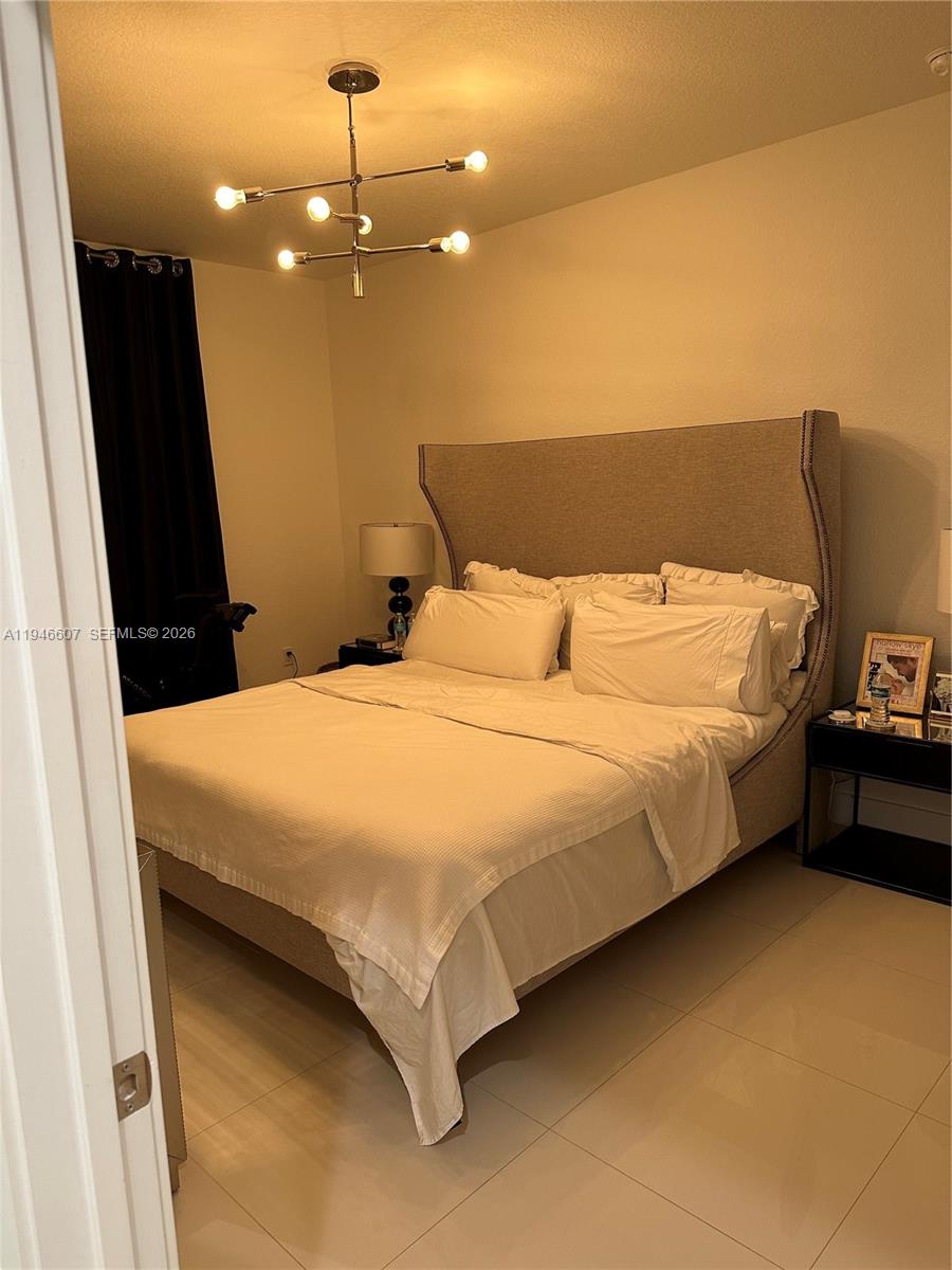 507 Southwest 91st Court, Unit 507 Miami, FL 33174 - Photo 6 of 15 a bed sitting in a bedroom next to a larger window