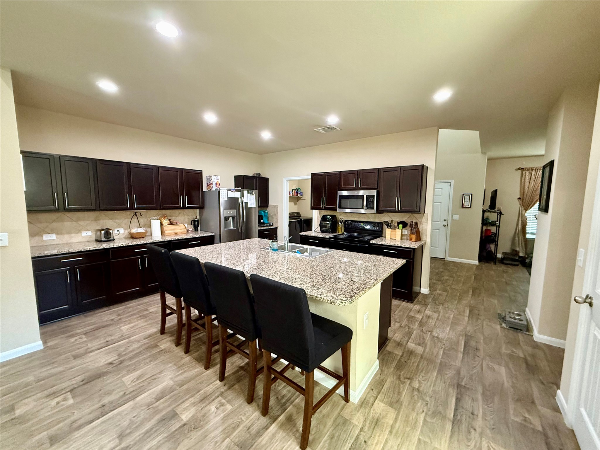 11700 Andesite Road Manor, TX 78653 - Photo 4 of 32 A well-appointed kitchen features a large central island and recessed lighting throughout, ideal for culinary creations and social gatherings.