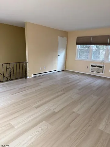 a view of a room with wooden floor and window