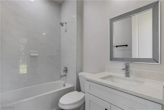 a bathroom with a granite countertop sink a toilet and shower