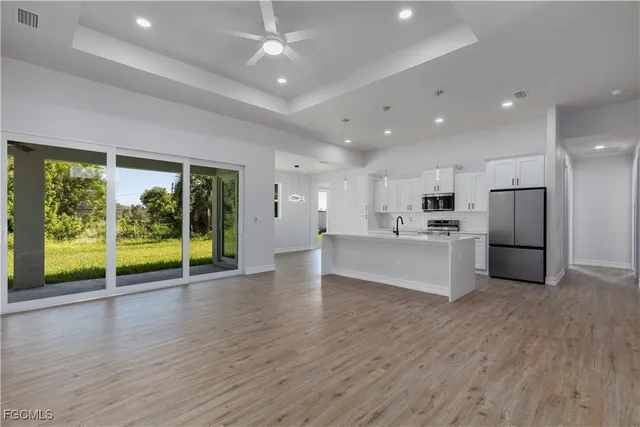 a view of kitchen with refrigerator and wooden floor
