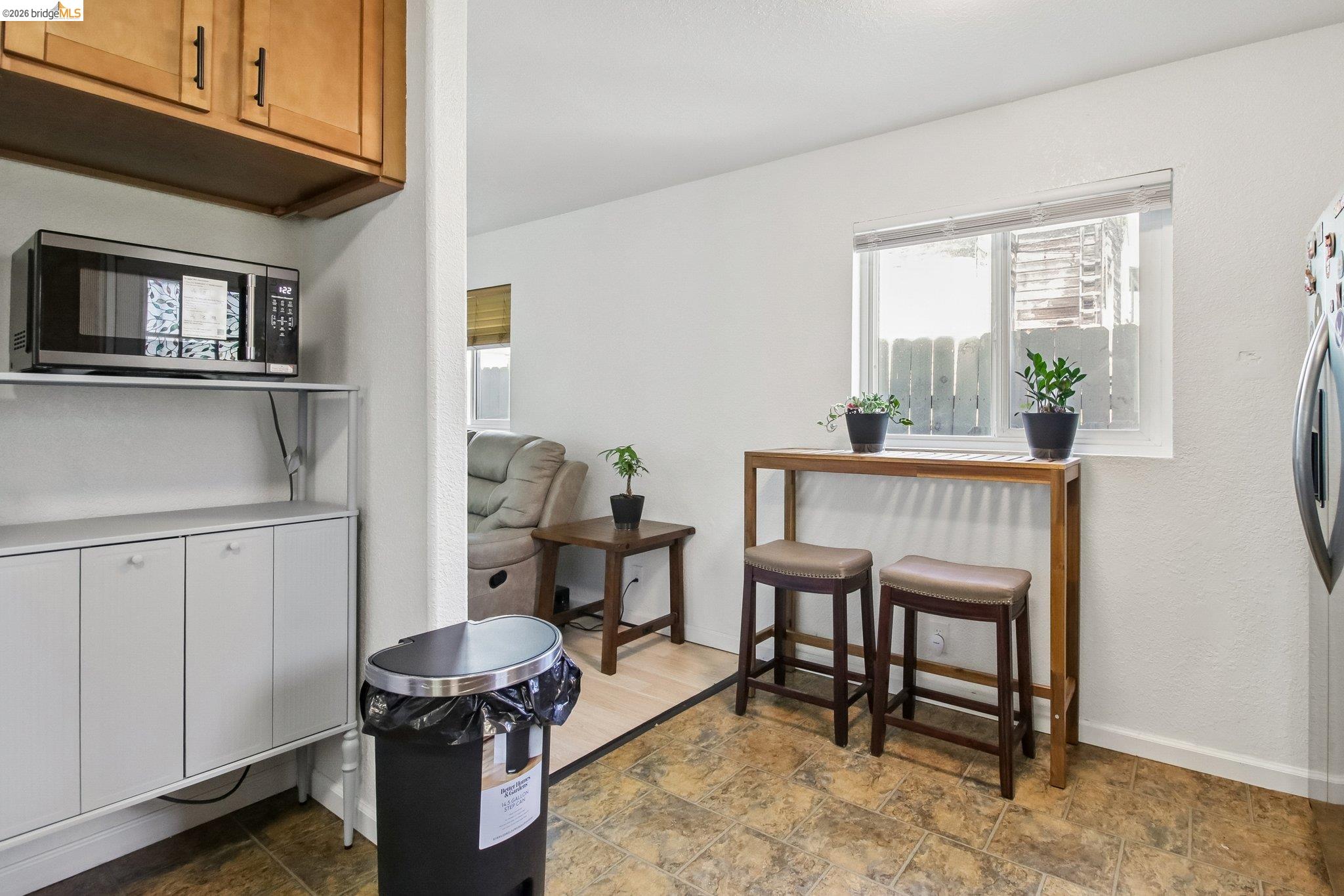 874 Pine Street Oakland, CA 94607 - Photo 11 of 39 Kitchen area featuring warm-toned cabinetry, a window with natural light, and tile flooring