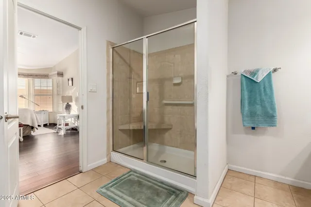 a bathroom with a glass shower door and a window