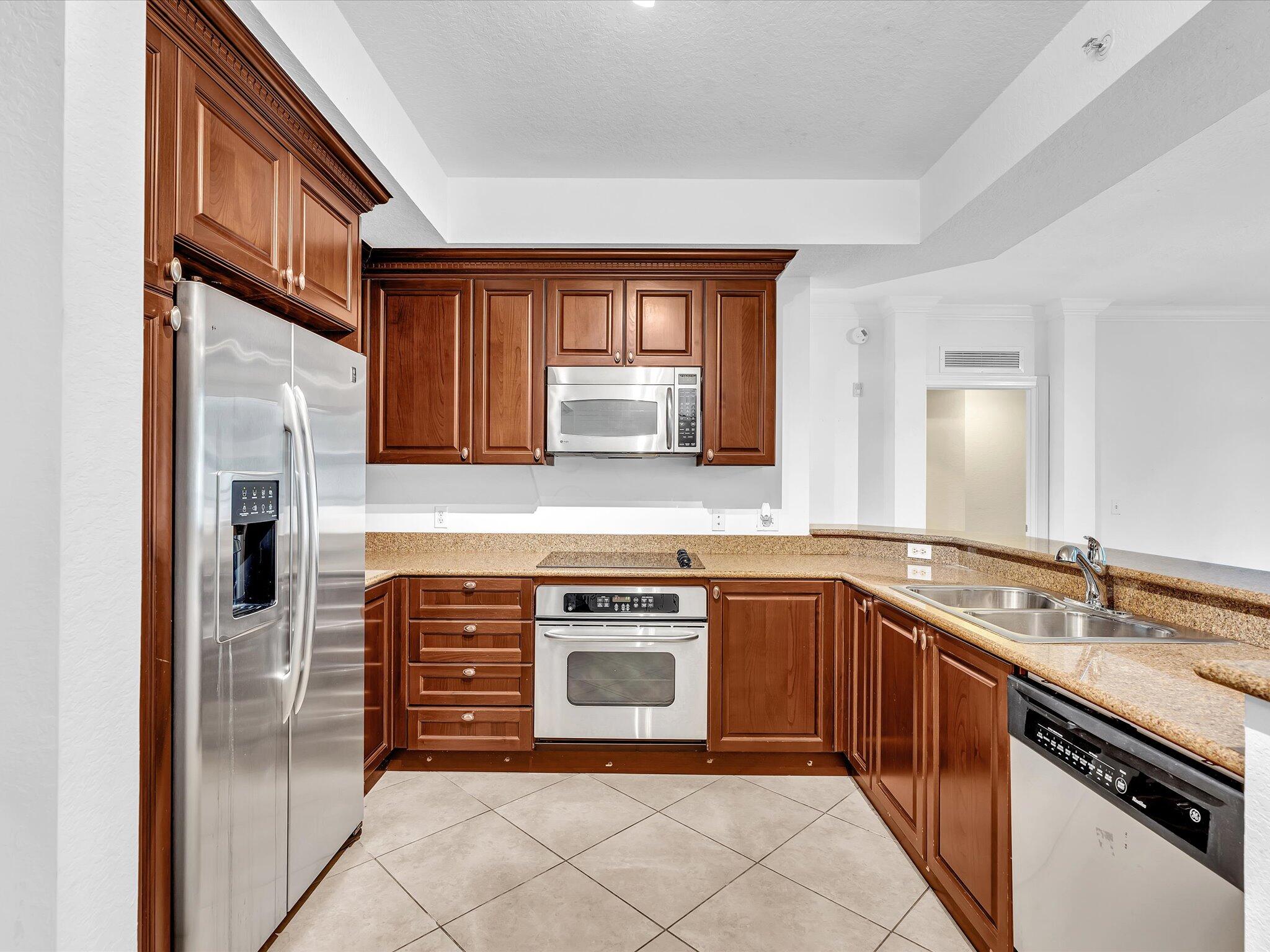 4303 Renaissance Way, Unit 303 Boynton Beach, FL 33426 - Photo 22 of 74 a kitchen with stainless steel appliances granite countertop a stove and a sink