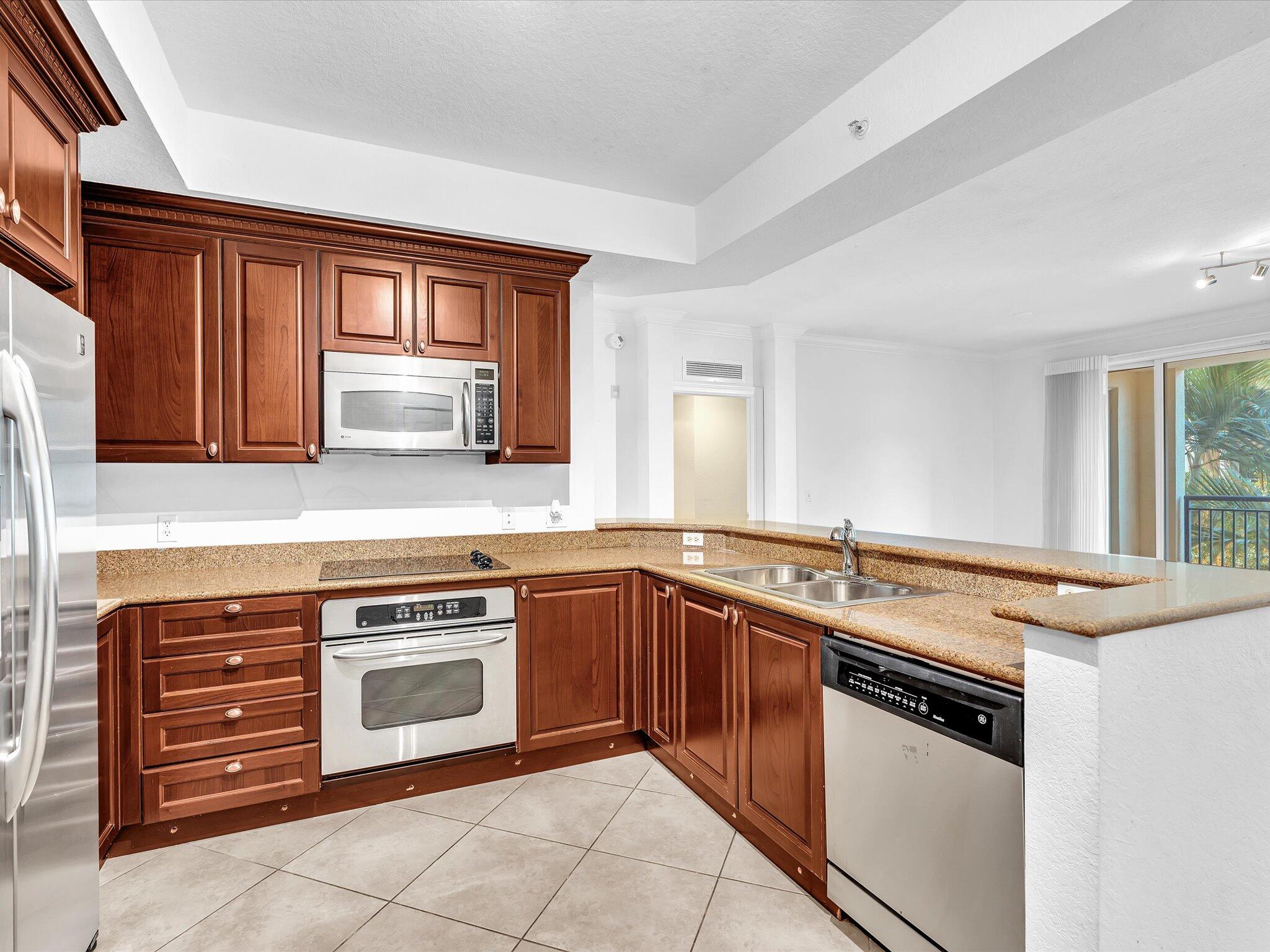 4303 Renaissance Way, Unit 303 Boynton Beach, FL 33426 - Photo 23 of 74 a kitchen with a stove sink and cabinets