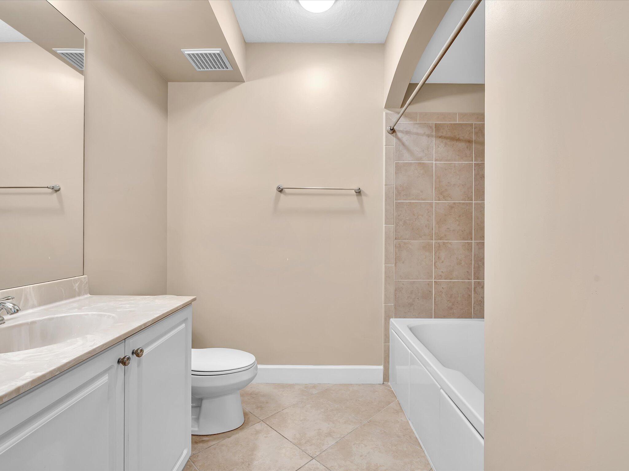 4303 Renaissance Way, Unit 303 Boynton Beach, FL 33426 - Photo 36 of 74 a bathroom with a granite countertop bathtub shower sink vanity and toilet