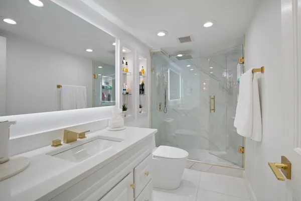 a bathroom with a sink a toilet and shower
