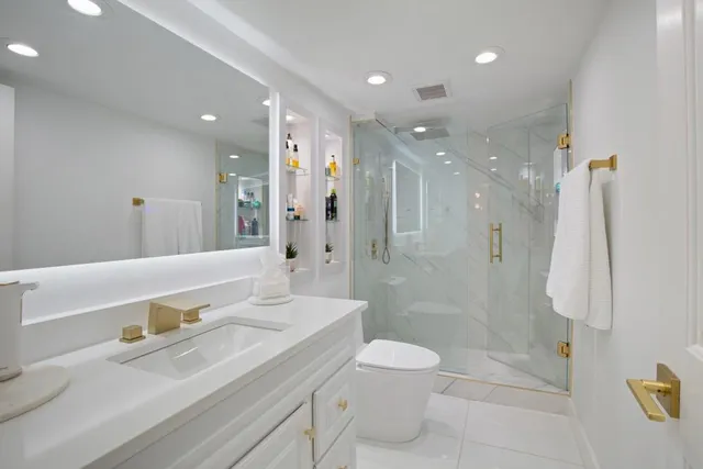 a bathroom with a sink a toilet and shower