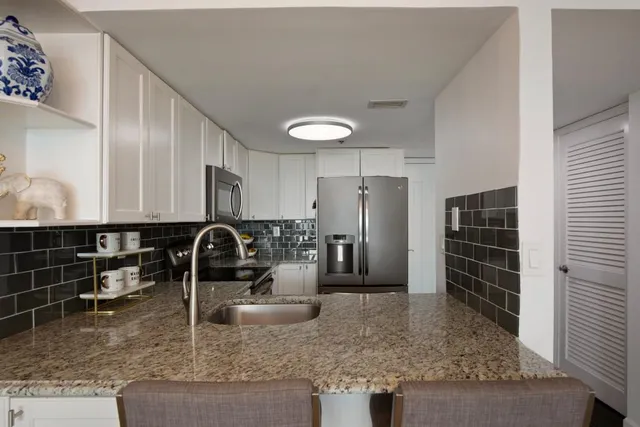 a kitchen with a refrigerator a stove and cabinets