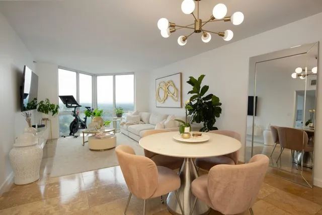 a view of a dining room with furniture a chandelier and a window