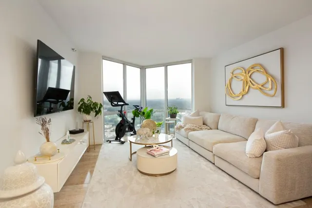 a living room with furniture a flat screen tv and a large window