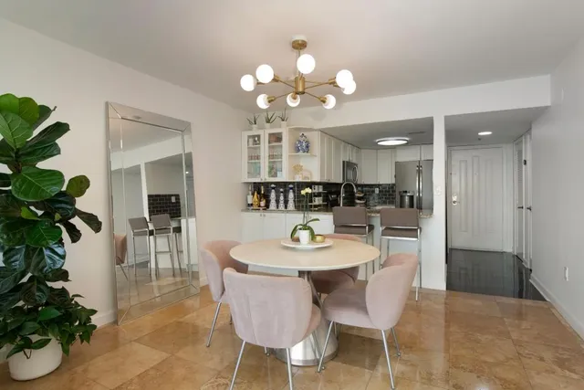 a dining room with wooden floor a chandelier a glass table and chairs