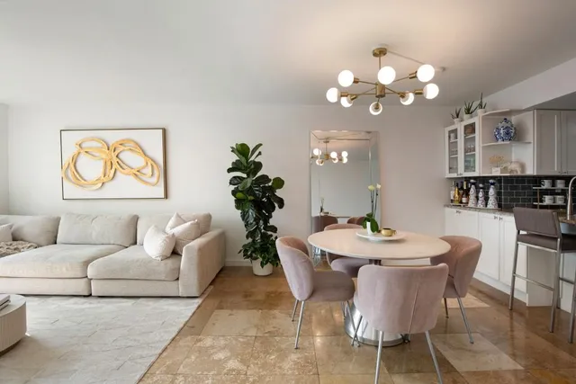 a living room with furniture a chandelier and a mirror