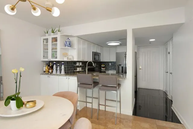a kitchen with stainless steel appliances kitchen island granite countertop a table and chairs