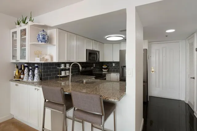 a kitchen with stainless steel appliances granite countertop a sink refrigerator and microwave
