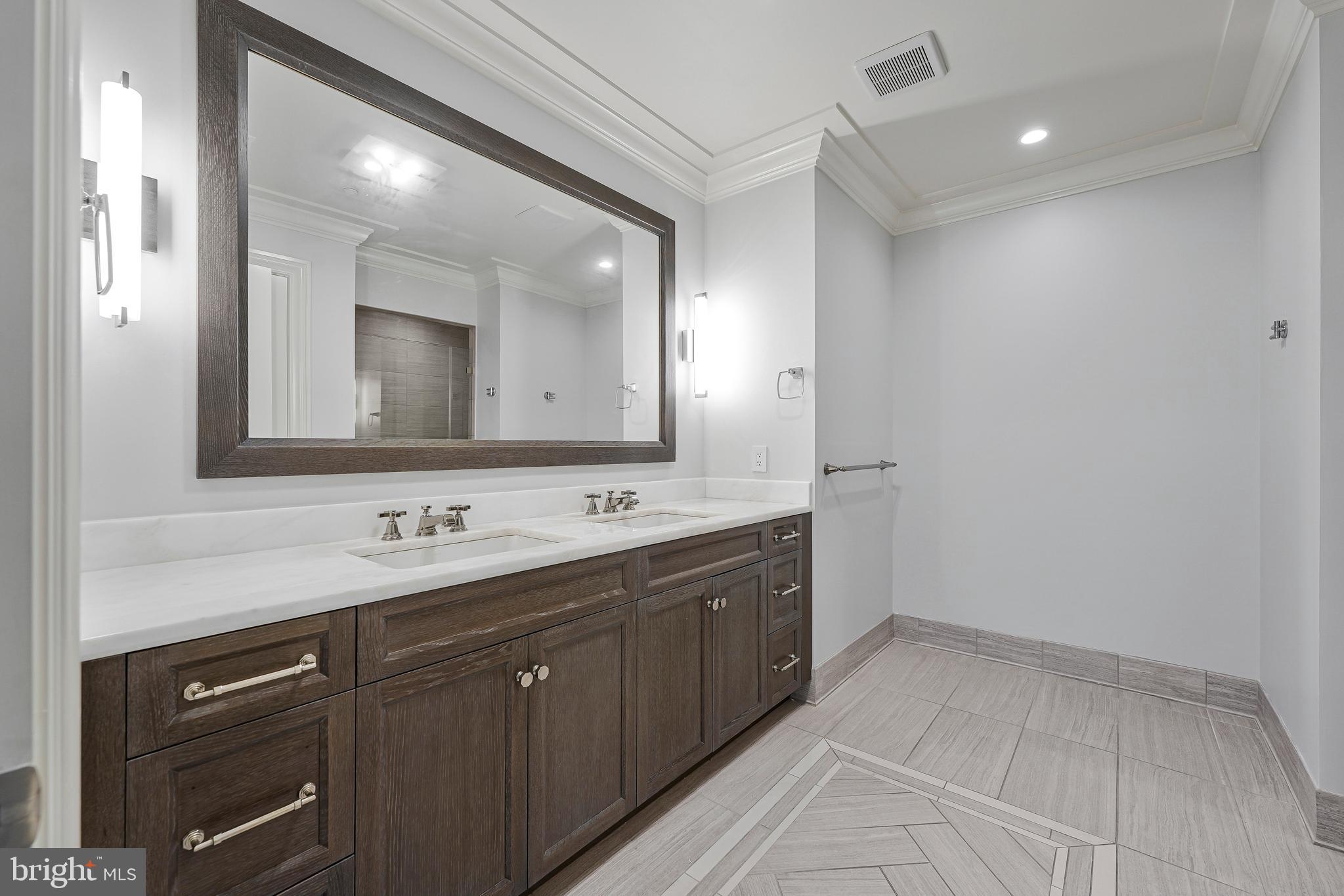 6900 Fleetwood Road, Unit 317 McLean, VA 22101 - Photo 19 of 56 a bathroom with a double vanity sink and mirror