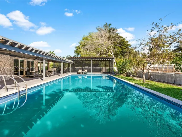 a spacious bedroom with a bed a table and windows