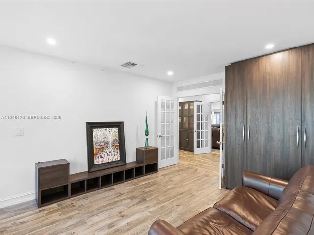 a living room with furniture gym equipment and large windows