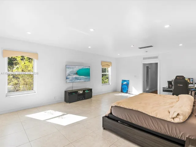 an aerial view of residential houses with outdoor space and trees