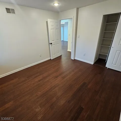 an empty room with wooden floor and sink