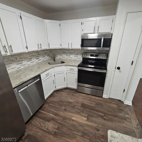 a kitchen with granite countertop a stove and a sink