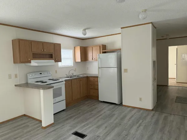 a kitchen with a refrigerator stove and wooden cabinets