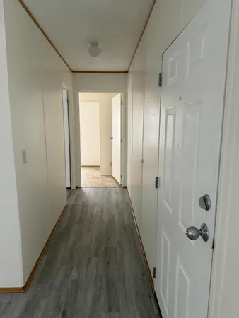 a view of a hallway with wooden floor