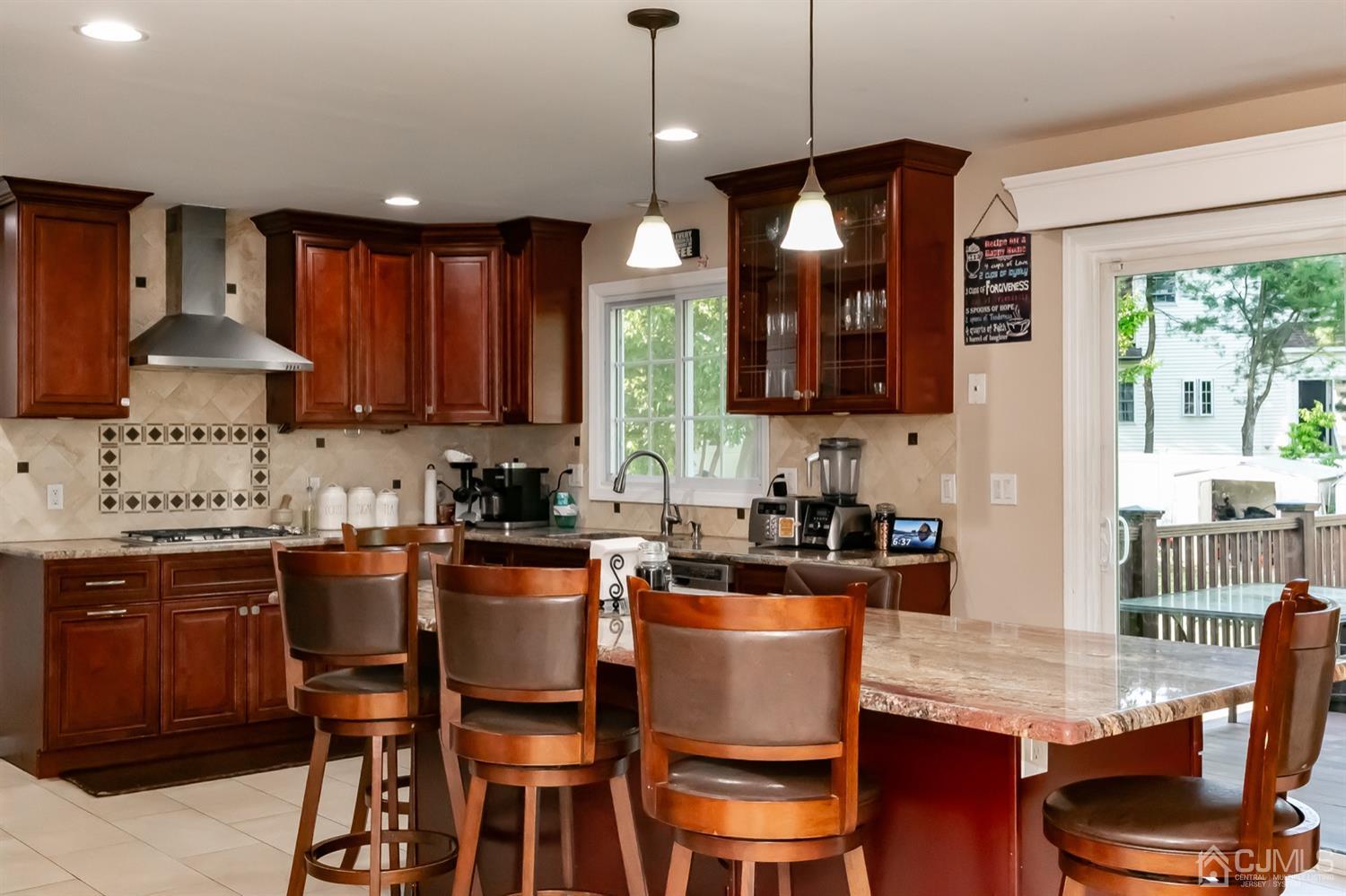 8 Peppermint Hill Road North Brunswick, NJ 08902 - Photo 19 of 32 a kitchen with stainless steel appliances granite countertop a stove top oven a sink dishwasher a dining table and chairs with wooden floor
