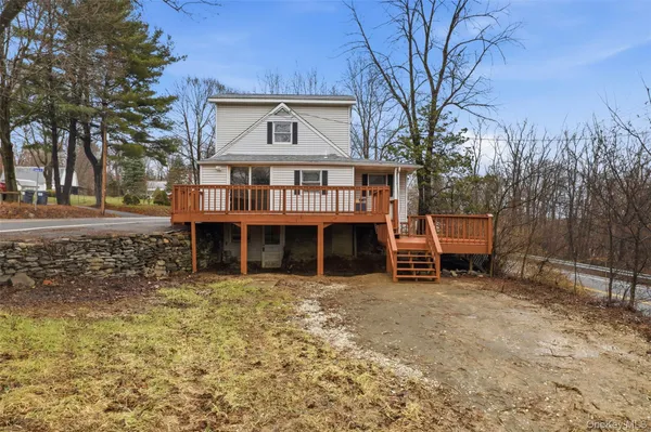 a view of a wooden house with a large trees and wooden fence